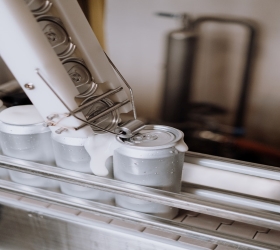 An image of blank beer cans having lids attached along a conveyor system.